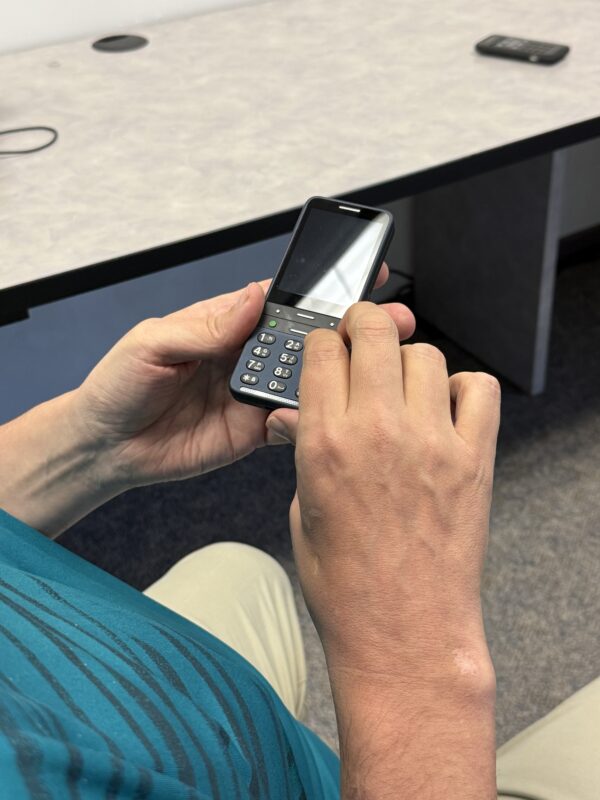 A man holding and demonstrating the Blindshell smartphone