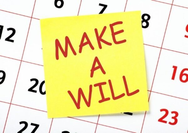 A post-it reading Make a Will placed on a calendar page