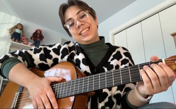 A smiling Luka Santin holding a guitar