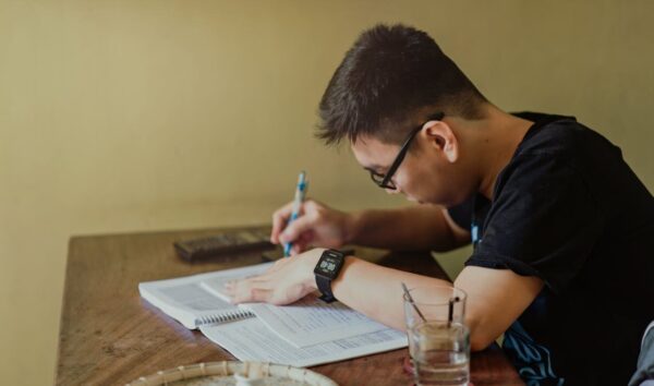 A student sitting at a table doing homework.