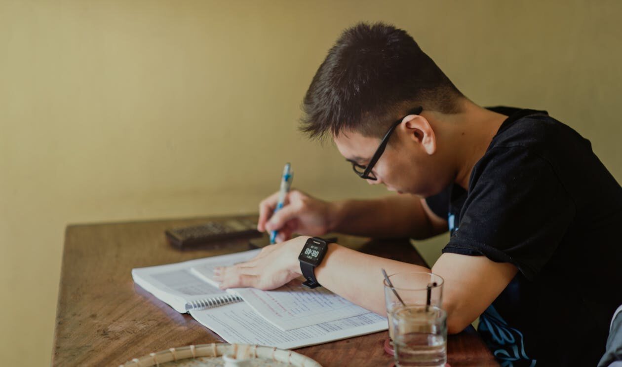 A student sitting at a table doing homework.
