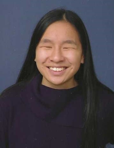 A person with long, straight dark hair smiling for the camera.