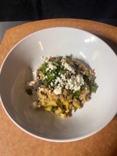 A delicious looking grain bowl consisting of farro topped with various vegetables and crumbled cheese