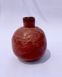 Red globe-shaped jar with narrow mouth extending from the top.