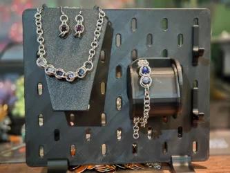 A set of earrings, a bracelet and a necklace. Colored circle beads sit in silver ring cages
