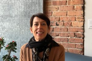 Jodi Nachtwey sitting in front of a brink wall