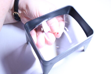 Squeezing blood from a finger under a magnifier.
