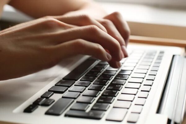 Hands typing on a computer keyboard